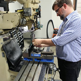 Ximedica Minneapolis employee working on manufacturing machine